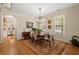 Sunlit dining room showcases hardwood floors, chandelier, and views to the kitchen and a treelined street at 4900 Fairmont Way, Roswell, GA 30075