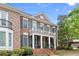 Elegant brick home featuring a welcoming front porch and a second-story balcony, enhanced by lush landscaping at 4900 Fairmont Way, Roswell, GA 30075