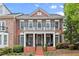 Charming two-story red brick home with a welcoming front porch and manicured landscaping at 4900 Fairmont Way, Roswell, GA 30075