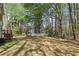 View of spacious backyard with mature trees and white fence at 100 Julia Ct, Fayetteville, GA 30214