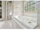 Close-up of a luxurious tub beneath a glass block window at 100 Julia Ct, Fayetteville, GA 30214