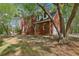 View of the house and garage with brick exterior and mature trees at 100 Julia Ct, Fayetteville, GA 30214