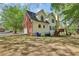 View of house and garage with brick and siding, and a backyard with mature trees at 100 Julia Ct, Fayetteville, GA 30214