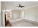 Open-concept living area with a fireplace, ceiling fan, and carpeted flooring that flows into the adjoining areas at 100 Julia Ct, Fayetteville, GA 30214