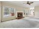 Spacious living room with a fireplace, ceiling fan, carpeted floors, and ample natural light from many windows at 100 Julia Ct, Fayetteville, GA 30214