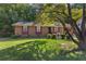 Charming single-story brick home featuring a well-maintained lawn and mature tree at 37 Crystal River Dr, Riverdale, GA 30274