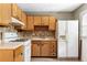 A well-lit kitchen with tiled backsplash, wooden cabinets, and a white refrigerator at 37 Crystal River Dr, Riverdale, GA 30274