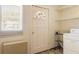 Functional laundry area with a washing machine, storage shelves, and a window for natural light at 37 Crystal River Dr, Riverdale, GA 30274