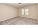 A spacious bedroom with neutral walls, plush carpet, and a window letting in natural light at 3835 Rifflepool Ct, Douglasville, GA 30135