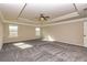 Spacious bedroom with a tray ceiling, fan, plush carpet, and multiple windows for lots of natural light at 3835 Rifflepool Ct, Douglasville, GA 30135