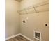 A minimalist laundry room featuring a wire shelf, hookups, and wood-look vinyl flooring at 3835 Rifflepool Ct, Douglasville, GA 30135