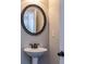 Stylish powder room with a pedestal sink and decorative mirror at 3835 Rifflepool Ct, Douglasville, GA 30135