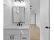 Modern bathroom featuring a white vanity with black fixtures and a mirror with decorative lighting above at 6120 Hutchins Dr, Buford, GA 30518