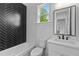 Modern bathroom features black herringbone tile accent wall, white marble walls, and a large mirror at 6120 Hutchins Dr, Buford, GA 30518