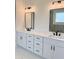 Bathroom featuring dual sinks, modern fixtures, and a large mirror, ideal for daily routines at 6120 Hutchins Dr, Buford, GA 30518