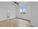 Bright bedroom featuring a ceiling fan, wood floors and a large window with a view of trees at 6120 Hutchins Dr, Buford, GA 30518
