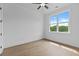 Sun-filled bedroom features wood floors, neutral walls, ceiling fan and a large window with a scenic view at 6120 Hutchins Dr, Buford, GA 30518