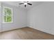 Bright bedroom features wood floors, neutral walls, ceiling fan and a large window with a scenic view at 6120 Hutchins Dr, Buford, GA 30518
