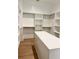 Walk-in closet featuring custom shelving and a large center island for organized storage at 6120 Hutchins Dr, Buford, GA 30518