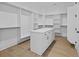 Spacious walk-in closet with custom shelving, cabinets, and hardwood floor at 6120 Hutchins Dr, Buford, GA 30518