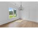 Bright dining room with hardwood floors, panel molding, a modern chandelier, and large windows at 6120 Hutchins Dr, Buford, GA 30518