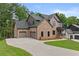 Stunning brick home with a three-car garage and a spacious driveway for ample parking at 6120 Hutchins Dr, Buford, GA 30518