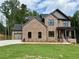 Beautiful two-story brick home with a manicured lawn, showcasing curb appeal at 6120 Hutchins Dr, Buford, GA 30518
