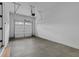 A well lit garage features an automatic door, concrete floors and a pedestrian door at 6120 Hutchins Dr, Buford, GA 30518