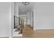 Bright hallway with hardwood floors, white walls, and modern black iron handrail staircase at 6120 Hutchins Dr, Buford, GA 30518