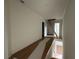 Upstairs landing and hallway with hardwood floors and a ladder to the attic at 6120 Hutchins Dr, Buford, GA 30518
