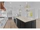 Well-appointed kitchen features a large island, stainless steel appliances, custom cabinetry, and herringbone backsplash at 6120 Hutchins Dr, Buford, GA 30518