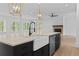 Kitchen island features a farmhouse sink, black cabinetry, and stainless steel dishwasher at 6120 Hutchins Dr, Buford, GA 30518