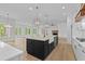 Contemporary kitchen with an island, stainless steel sink, and modern fixtures is open to the living space at 6120 Hutchins Dr, Buford, GA 30518