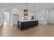 Modern kitchen with island, pendant lighting, white cabinets, stainless appliances, and stylish backsplash at 6120 Hutchins Dr, Buford, GA 30518