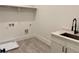 Well-lit laundry room featuring a sink, countertop, and storage, designed for efficiency at 6120 Hutchins Dr, Buford, GA 30518