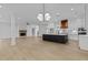 Open concept living space featuring a modern kitchen, fireplace, and wood floors at 6120 Hutchins Dr, Buford, GA 30518
