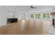 Spacious open-concept living room with hardwood floors, fireplace, and adjacent modern kitchen with island at 6120 Hutchins Dr, Buford, GA 30518