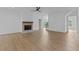 Well-lit living room showcasing a fireplace with wooden mantel and hardwood floors, with staircase to upper level at 6120 Hutchins Dr, Buford, GA 30518