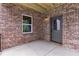 Cozy covered patio with brick walls and a convenient access door at 6120 Hutchins Dr, Buford, GA 30518