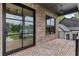 Covered porch with brick flooring, a modern light fixture, and a stylish steel frame door at 6120 Hutchins Dr, Buford, GA 30518