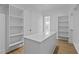 Bright walk-in closet features custom shelving, island and wood floors providing both style and organization at 6120 Hutchins Dr, Buford, GA 30518