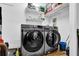 A laundry room with modern Samsung washer and dryer units, and shelving for storage at 670 Westbrook Pl, Lawrenceville, GA 30044