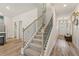 Hallway view showcasing the staircase, front door, and stylish decor with wood-look flooring for a modern touch at 316 Shine Dr, Stockbridge, GA 30281