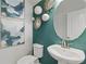 Stylish powder room with a decorative mirror, modern vanity, and teal accent wall at 316 Shine Dr, Stockbridge, GA 30281