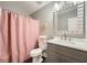 A bathroom with a gray vanity, quartz countertop, and pink shower curtain at 9053 Franklin Ct, Jonesboro, GA 30238