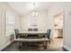 A dining room featuring a modern chandelier, a wooden table, and a bench at 9053 Franklin Ct, Jonesboro, GA 30238