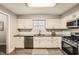 An open kitchen with white cabinets, gray countertops, and stainless steel appliances at 9053 Franklin Ct, Jonesboro, GA 30238