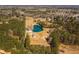 Picturesque aerial view highlighting a pristine pond and homes nestled amongst lush trees, offering a private retreat at 96 Sam Alexander Rd, Douglasville, GA 30134
