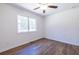 Simple bedroom featuring wood floors, a ceiling fan, and a window providing natural light at 96 Sam Alexander Rd, Douglasville, GA 30134