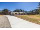 Long concrete driveway leading to a charming single-story home with a detached two-car garage at 96 Sam Alexander Rd, Douglasville, GA 30134